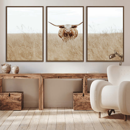 Texas Longhorn bull standing alone in dry grass with neutral tones, ideal for rustic western or cowboy-themed wall decor.