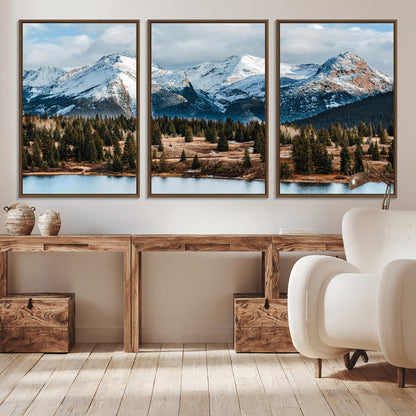 Framed canvas of snowy mountain peaks with pine forest and alpine lake, perfect for winter cabin or wilderness-inspired home decor.