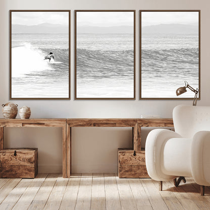 Monochrome photo of a surfer riding a wave with distant mountains, ideal for coastal motion or black and white surf-themed wall decor.