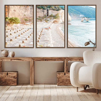 Wall art of a calm Mediterranean beach with rows of sun loungers and umbrellas in soft pastel tones, perfect for light coastal or vacation-themed decor.