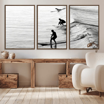 Black and white photo of surfers riding waves in a moody, high-contrast scene, ideal for modern coastal or surf-inspired home decor.