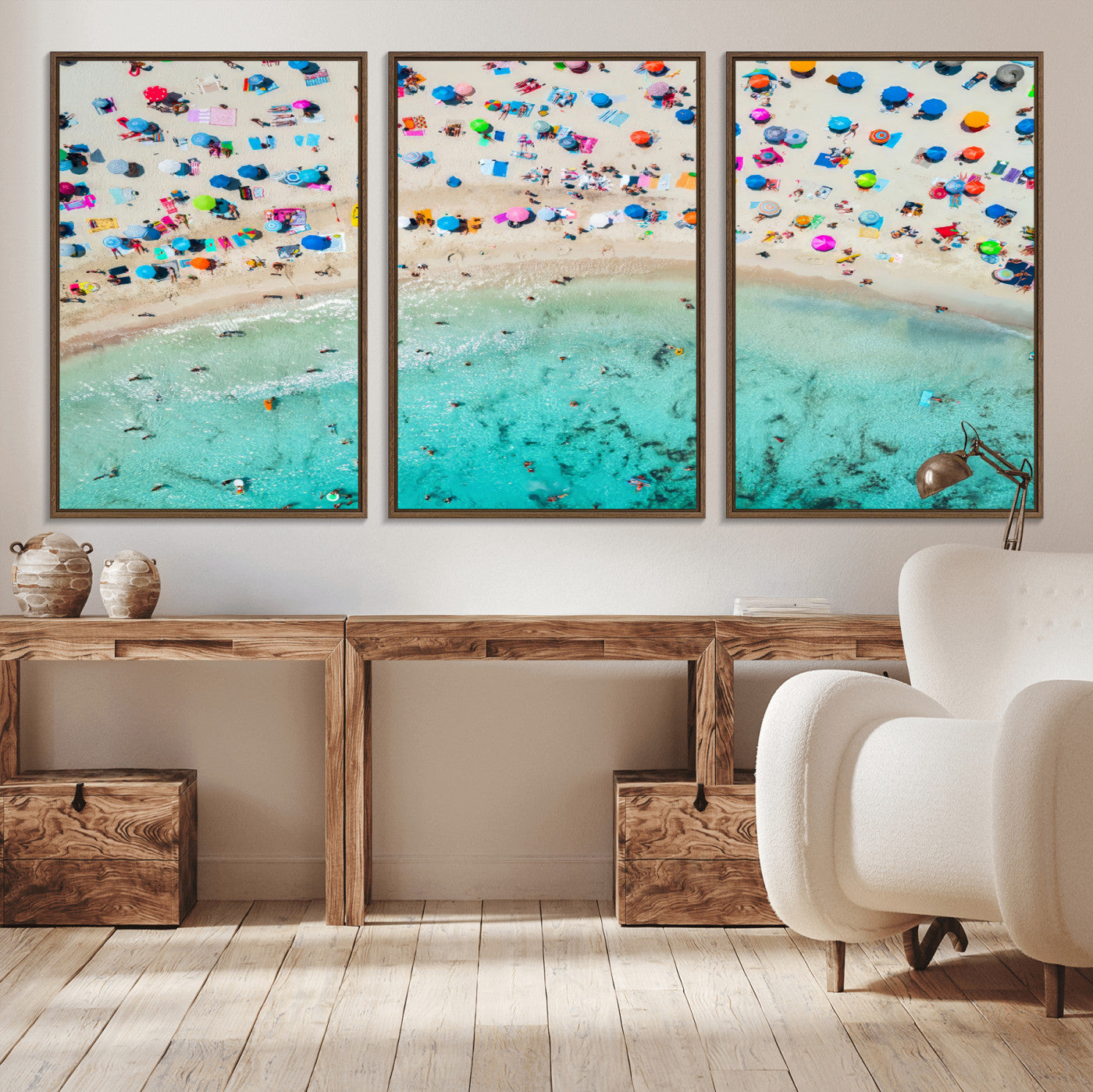 Aerial view of a vibrant beach filled with colorful umbrellas and people enjoying the turquoise ocean, capturing a lively summer vacation scene.
