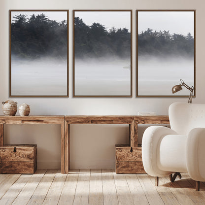 A lone surfer carrying a board through a misty shoreline, surrounded by dense trees and fog, creating a peaceful and mysterious coastal scene.