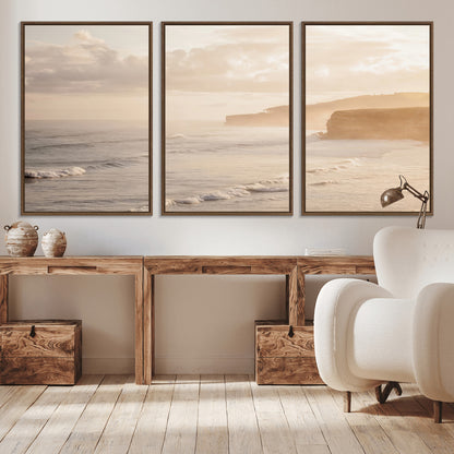 Golden hour seascape with misty cliffs and gentle waves rolling towards the shore, capturing a tranquil and warm coastal atmosphere.