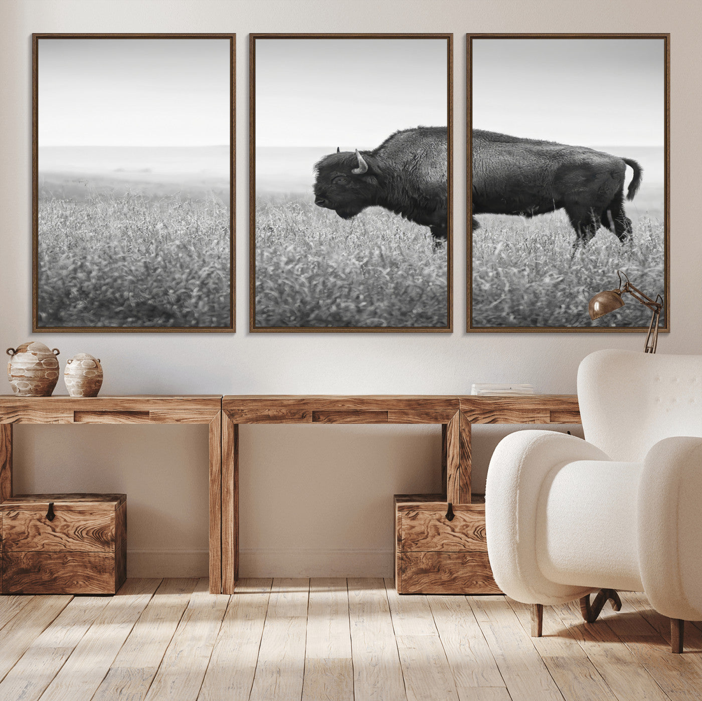A black and white photograph of a majestic bison standing in a vast grassy prairie, evoking a sense of wilderness and strength.