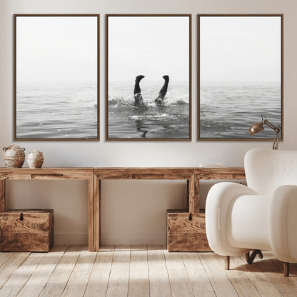 A black and white minimalist water scene capturing a playful splash as a swimmer dives upside down, creating a carefree and artistic aquatic aesthetic.