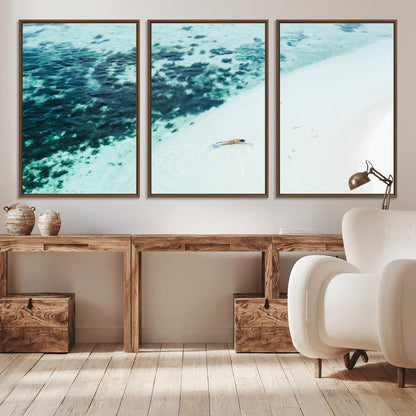 Canvas featuring an aerial view of a swimmer in shallow turquoise waters with coral patterns, ideal for tropical coastal home decor.