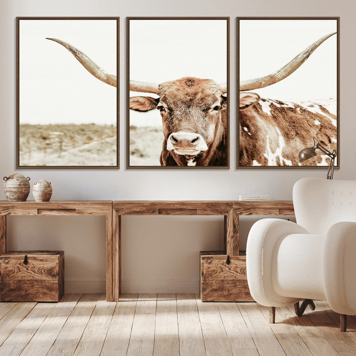 A Texas longhorn bull with wide horns, standing in a dry field under soft light, ideal for rustic farmhouse or western-themed interiors.