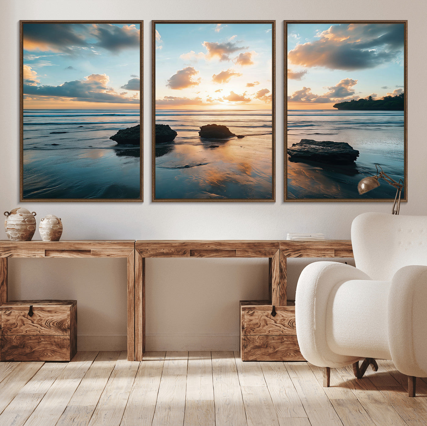 A serene beach at sunset with vibrant clouds, calm water, and rocks in the foreground reflecting the warm colors of the setting sun.