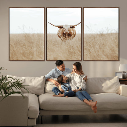Texas Longhorn bull standing alone in dry grass with neutral tones, ideal for rustic western or cowboy-themed wall decor.
