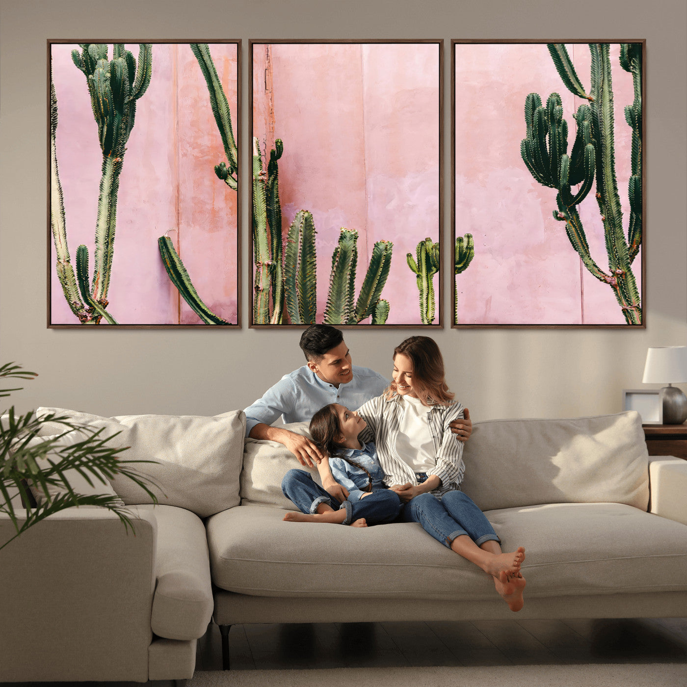Framed canvas of tall green cacti against a soft pink wall, ideal for modern desert or colorful southwest-inspired home decor.
