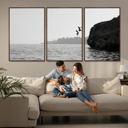 Black and white canvas of two figures cliff jumping into the sea, captured with moody tones, ideal for modern coastal or adventure-themed home decor.   2/2