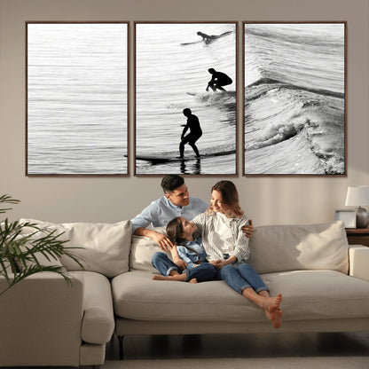Black and white photo of surfers riding waves in a moody, high-contrast scene, ideal for modern coastal or surf-inspired home decor.