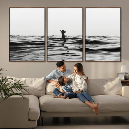 Black and white ocean with a hand making a surfer sign among dark waves, creating a dramatic and minimalist seascape with bold contrast.