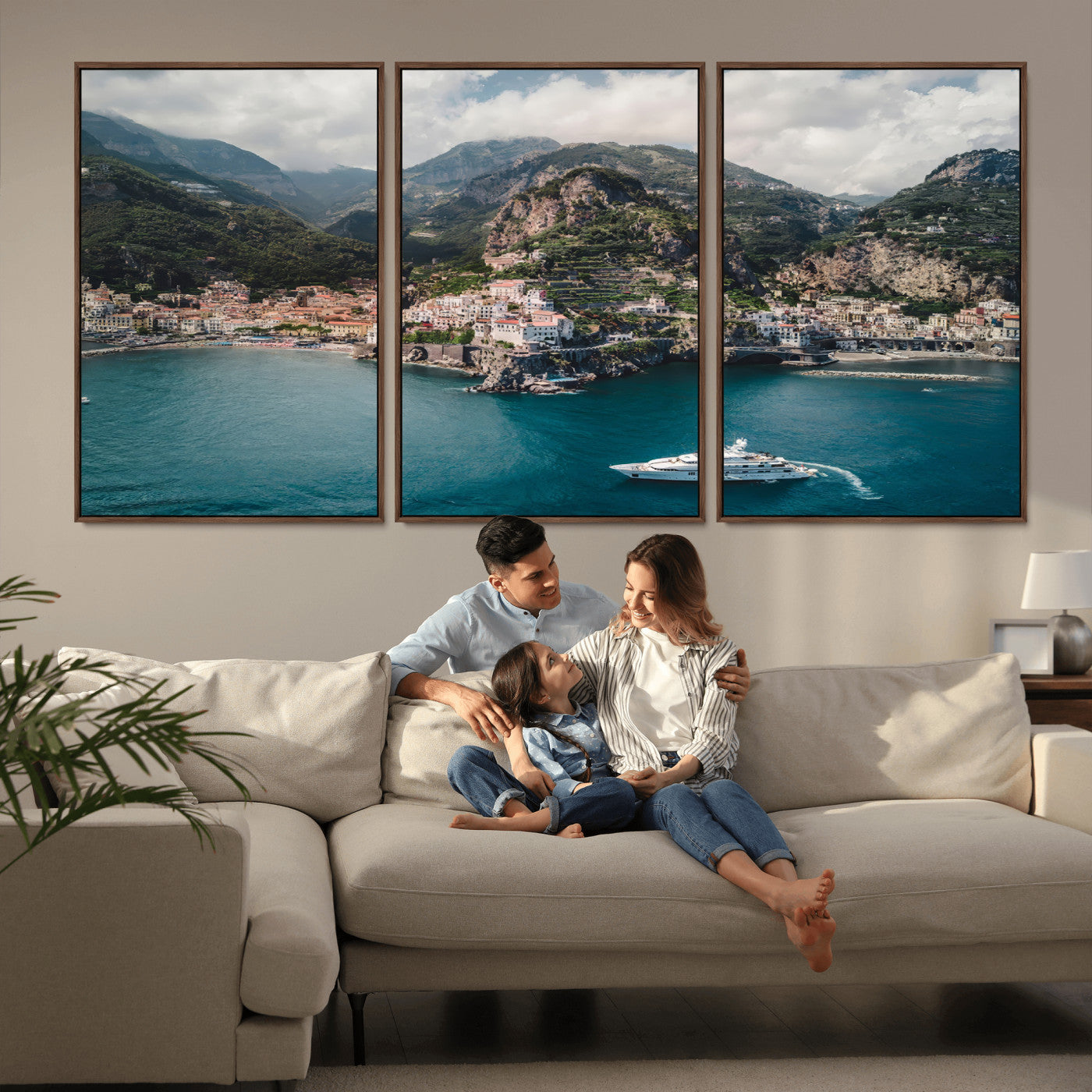 Aerial view of Amalfi Coast, Italy, with colorful hillside houses, lush green mountains, and a luxury yacht sailing in turquoise waters.