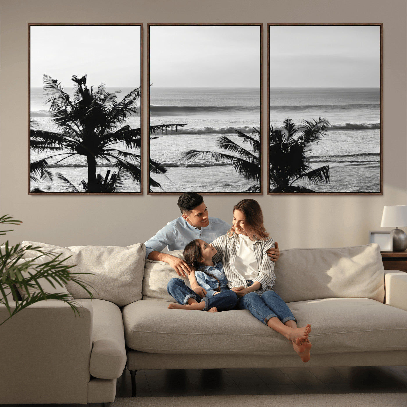 Black and white view of ocean waves crashing on a tropical coastline, framed by silhouetted palm trees under a vast, open sky.