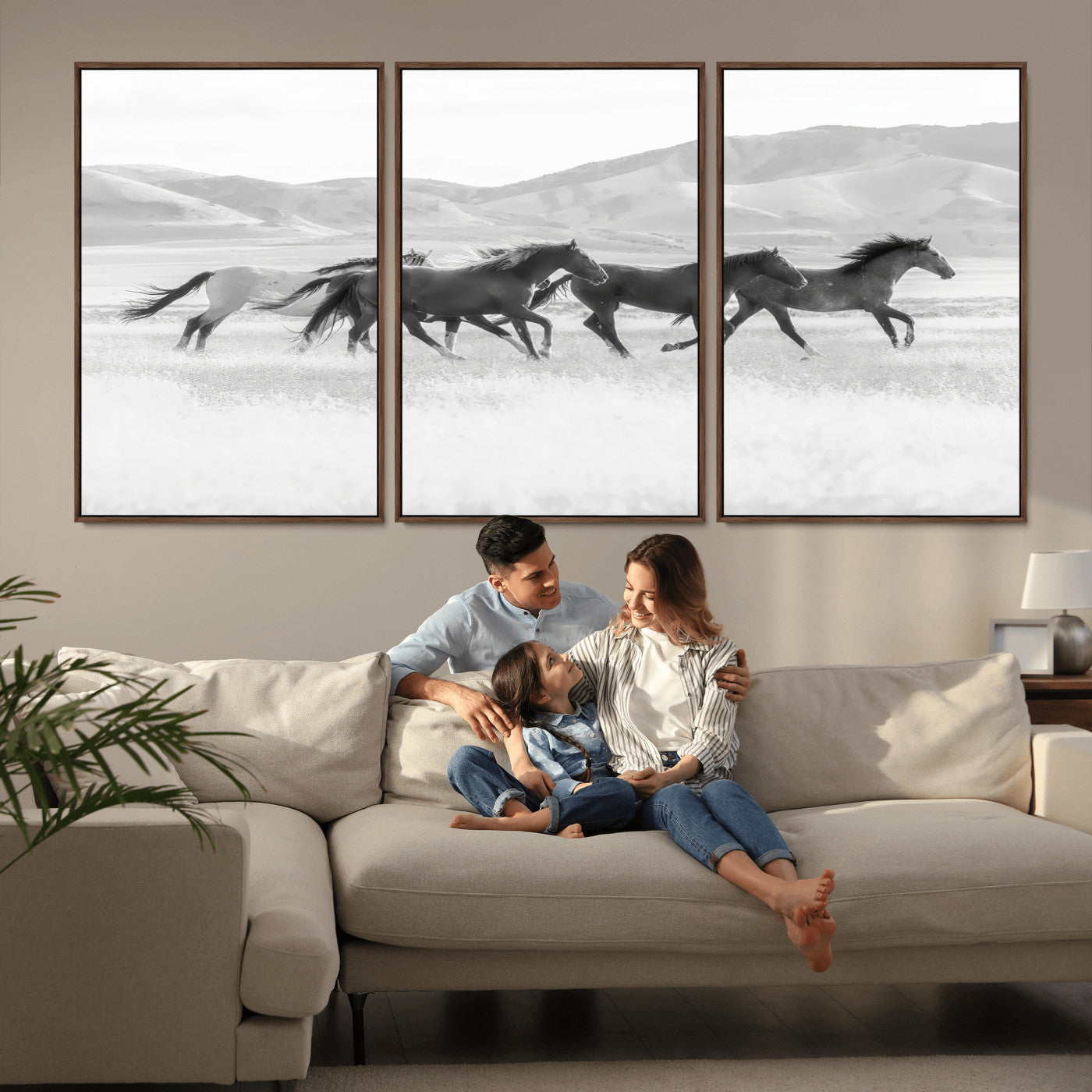 A black and white image of wild horses running freely across an open grassland, capturing the power and beauty of untamed nature in a rustic western setting.