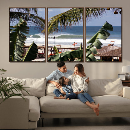Canvas wall art of a tropical surf scene framed by palm trees, with a surfer on the shore and waves rolling in, ideal for beach-themed decor.