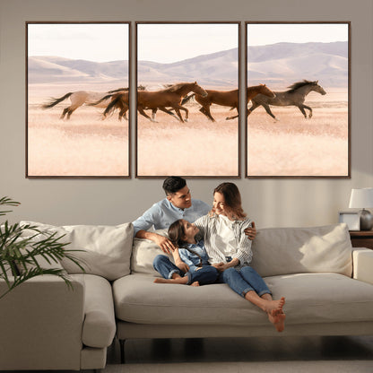 A herd of wild horses galloping through a sunlit desert plain with mountains in the background, perfect for rustic or western-themed wall decor.