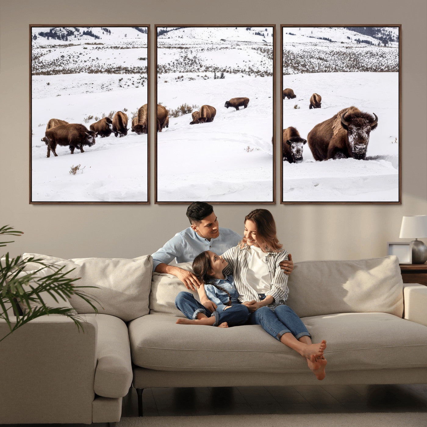 A herd of bison walking through deep snow in a mountain valley, perfect for rustic, cabin or western-themed wall decor.