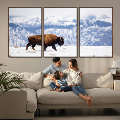A lone bison walks across snowy ground with blue-toned mountain range behind, ideal for rustic or western farmhouse interiors.