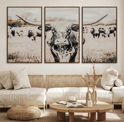 Canvas of a speckled Texas longhorn standing boldly in a field with a herd behind, perfect for rustic western or farmhouse wall decor.