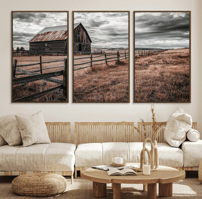 Framed canvas of a rustic barn under a moody sky with weathered fence and dark fields, ideal for farmhouse or rural-style wall decor.