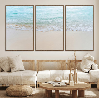 Soft shoreline with gentle aqua waves on smooth sand, ideal for minimalist coastal or pastel ocean-inspired home wall decor.