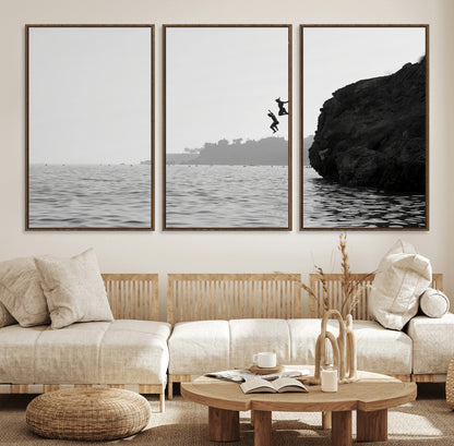 Black and white canvas of two figures cliff jumping into the sea, captured with moody tones, ideal for modern coastal or adventure-themed home decor.   2/2