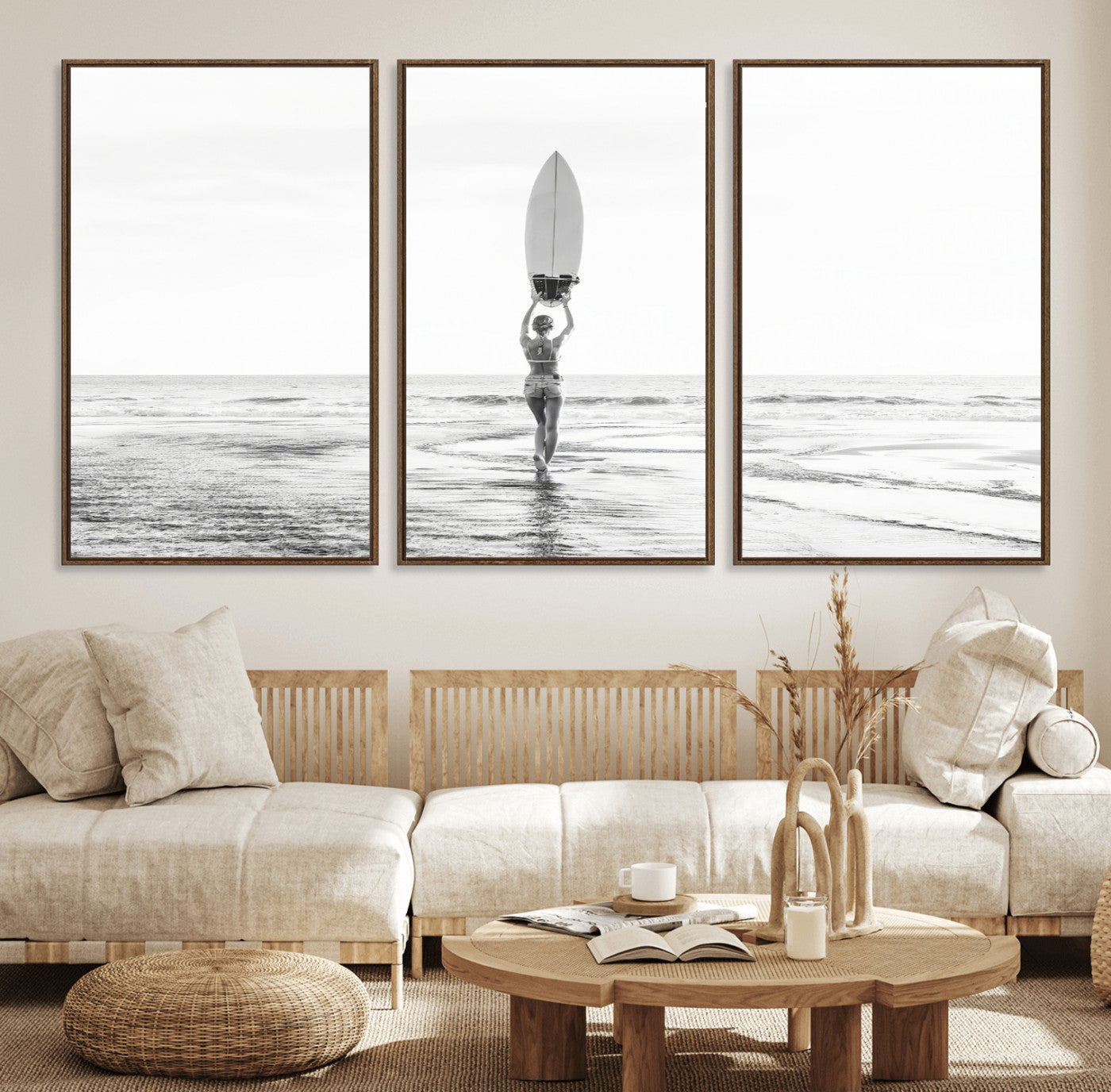 Black and white image of a female surfer holding a surfboard above her head while walking toward the ocean, creating a minimalist and bold coastal aesthetic.