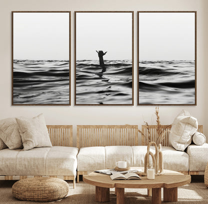 Black and white ocean with a hand making a surfer sign among dark waves, creating a dramatic and minimalist seascape with bold contrast.