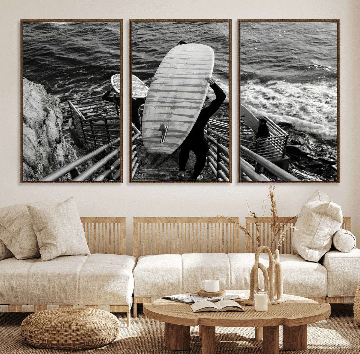 Black and white photo of surfers carrying boards down a rugged cliffside stairway, capturing a bold and adventurous coastal scene.