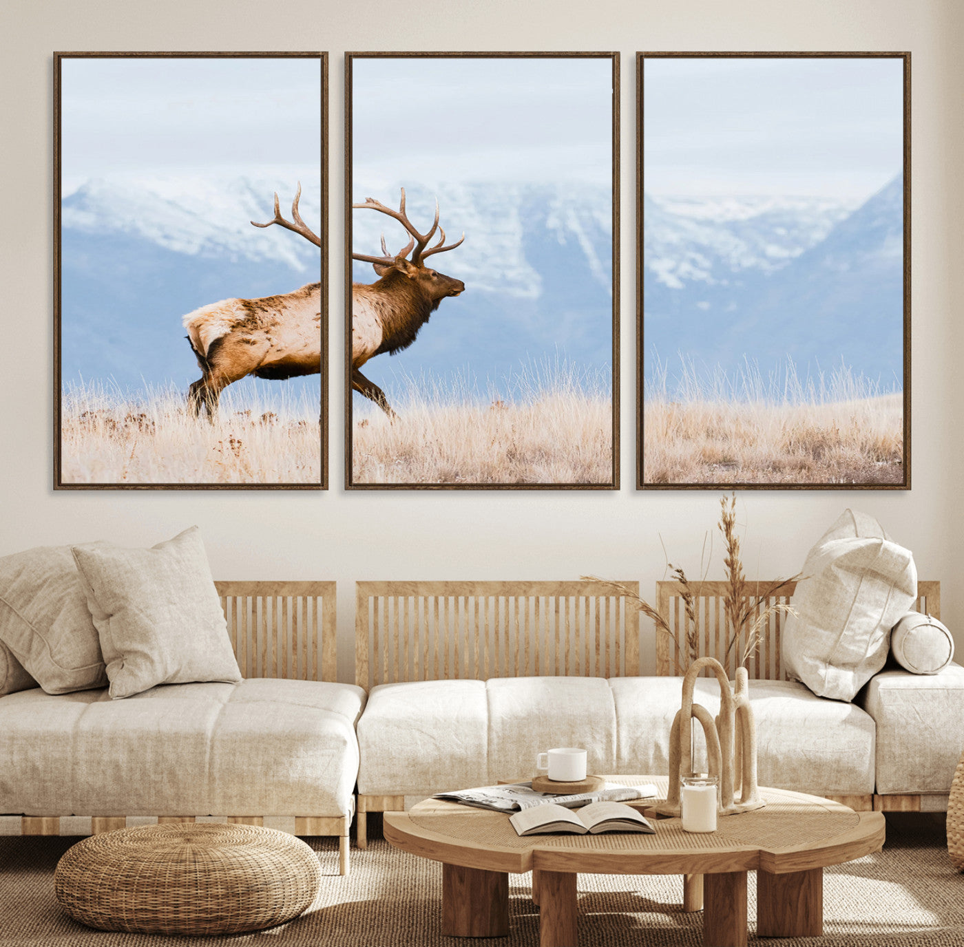 An elk walking on snowy grassland with majestic mountains in the background, ideal for rustic lodge or cabin wall decor.