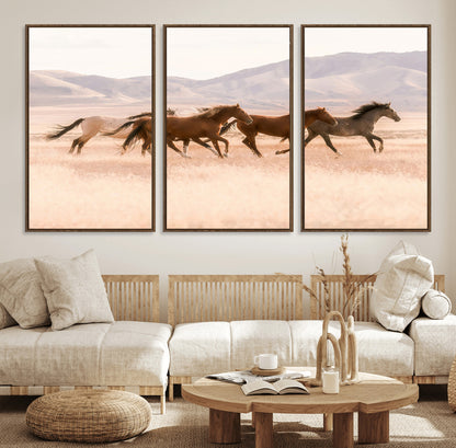 A herd of wild horses galloping through a sunlit desert plain with mountains in the background, perfect for rustic or western-themed wall decor.