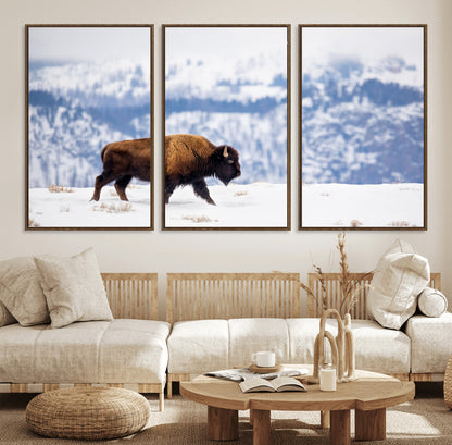A lone bison walks across snowy ground with blue-toned mountain range behind, ideal for rustic or western farmhouse interiors.