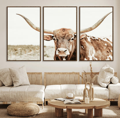 A Texas longhorn bull with wide horns, standing in a dry field under soft light, ideal for rustic farmhouse or western-themed interiors.