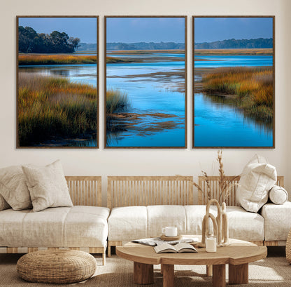 A peaceful marshland scene with calm blue water reflecting the surrounding grasses and trees, capturing the beauty of nature in a serene landscape.