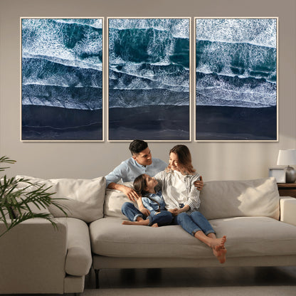 Canvas of aerial ocean waves crashing onto a black sand beach in moody tones, ideal for modern coastal or minimalist home decor.