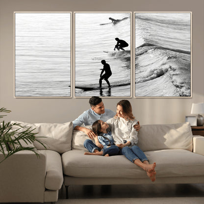 Black and white photo of surfers riding waves in a moody, high-contrast scene, ideal for modern coastal or surf-inspired home decor.