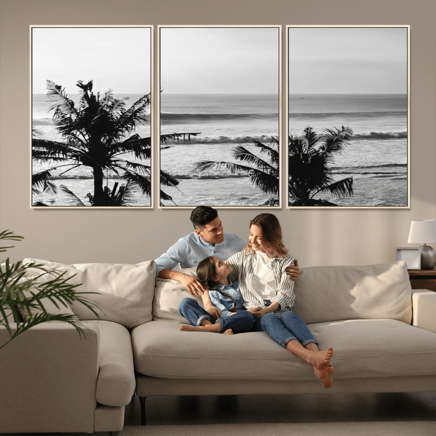 Black and white view of ocean waves crashing on a tropical coastline, framed by silhouetted palm trees under a vast, open sky.