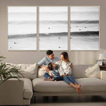 A monochrome photograph of swimmers gliding through gentle ocean waves, evoking a sense of calm and movement.