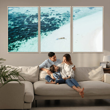 Canvas featuring an aerial view of a swimmer in shallow turquoise waters with coral patterns, ideal for tropical coastal home decor.