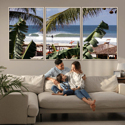 Canvas wall art of a tropical surf scene framed by palm trees, with a surfer on the shore and waves rolling in, ideal for beach-themed decor.