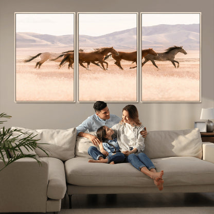 A herd of wild horses galloping through a sunlit desert plain with mountains in the background, perfect for rustic or western-themed wall decor.
