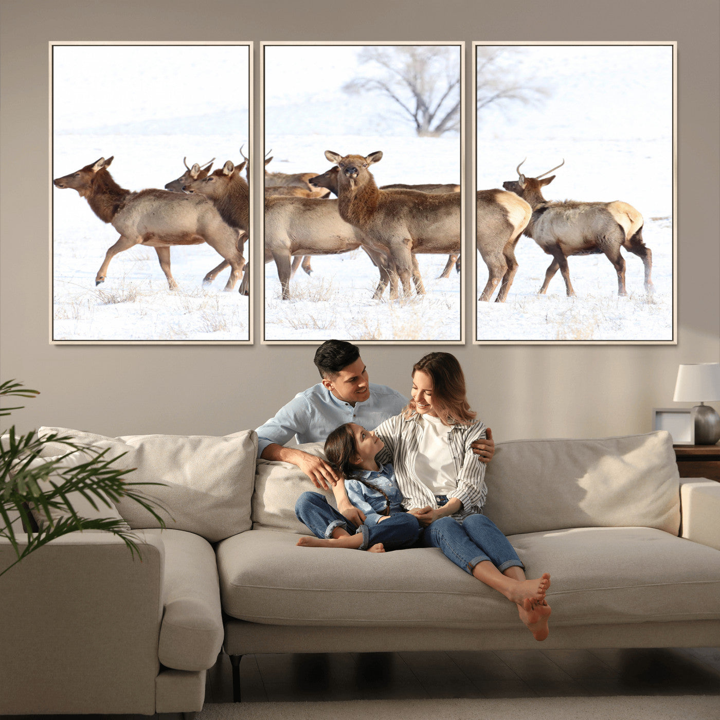A group of elk standing on snowy terrain with a tree in the background, perfect for rustic or lodge-style winter wall decor.
