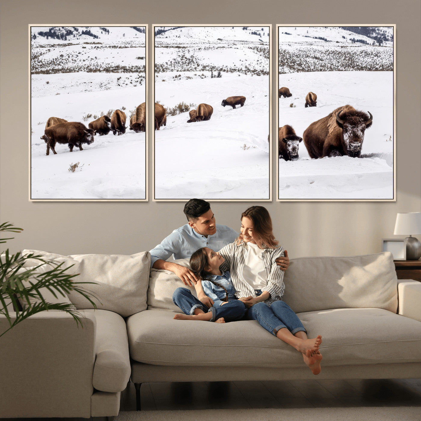 A herd of bison walking through deep snow in a mountain valley, perfect for rustic, cabin or western-themed wall decor.