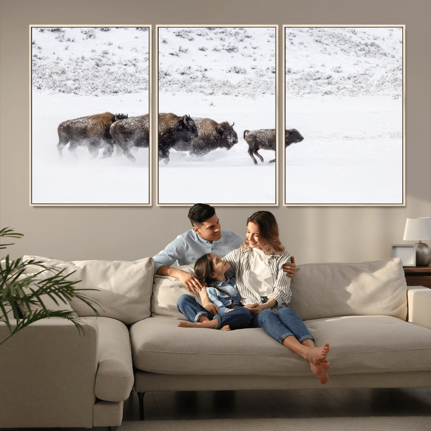 Bison herd running through a snowy open field with mountain backdrop, perfect for rustic or western-themed wall decoration.