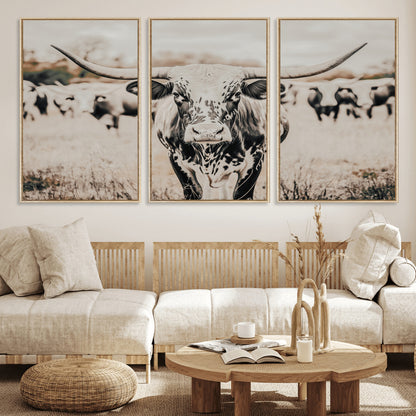 Canvas of a speckled Texas longhorn standing boldly in a field with a herd behind, perfect for rustic western or farmhouse wall decor.