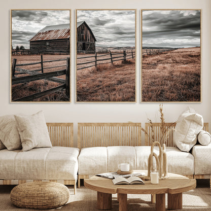 Framed canvas of a rustic barn under a moody sky with weathered fence and dark fields, ideal for farmhouse or rural-style wall decor.