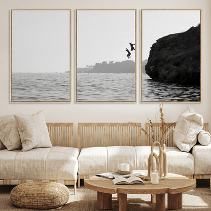 Black and white canvas of two figures cliff jumping into the sea, captured with moody tones, ideal for modern coastal or adventure-themed home decor.   2/2
